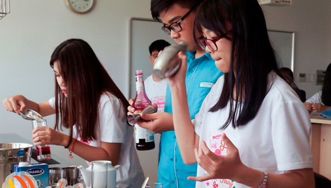 Các em học sinh được thử sức ở vai trò pha chế tại trường CĐ Quốc tế Pegasus. Ảnh: NVCC