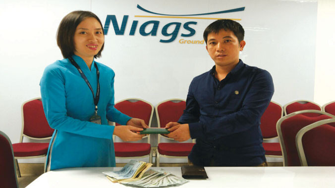 Anh Lê Đức Anh nhận lại chiếc ví chứa 95 triệu đồng và lá thư cảm ơn gửi đến những cán bộ, công nhân viên giúp đỡ anh.