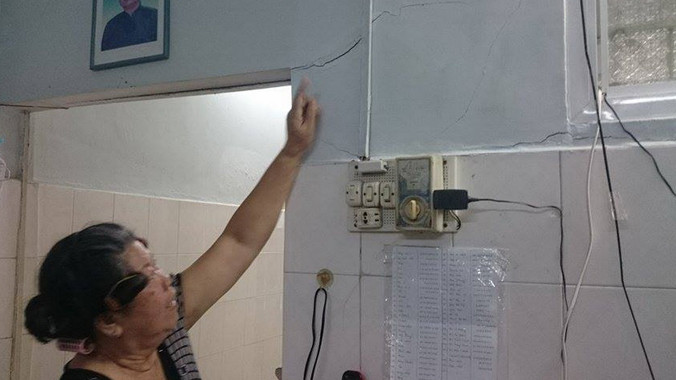 Cô giáo già chỉ vết nứt chi chít tường nhà.
