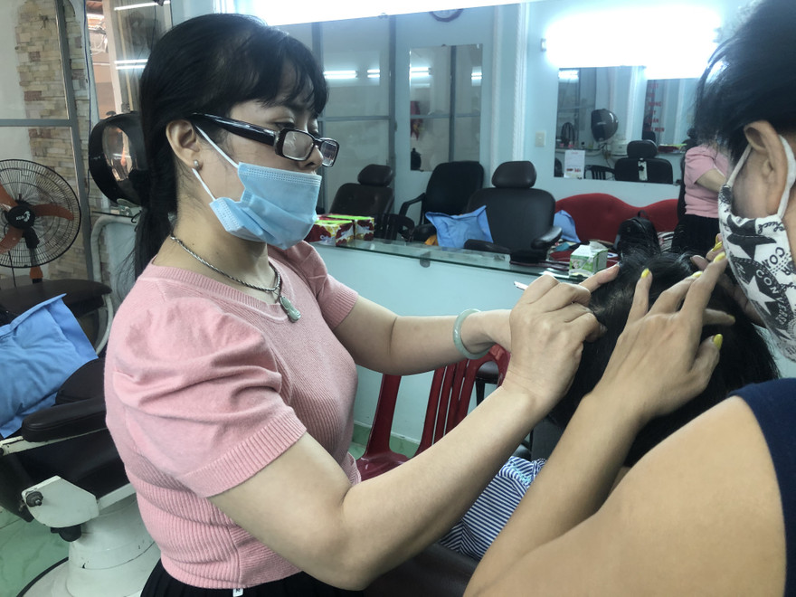 Chị Bùi Thị Tuyết, chủ tiệm Nhổ tóc bạc Tuyết (Bàn Cờ, quận 3, TPHCM) hành nghề “bới đen, tìm trắng” luôn có nguồn khách ruột ổn định Ảnh: U.P 