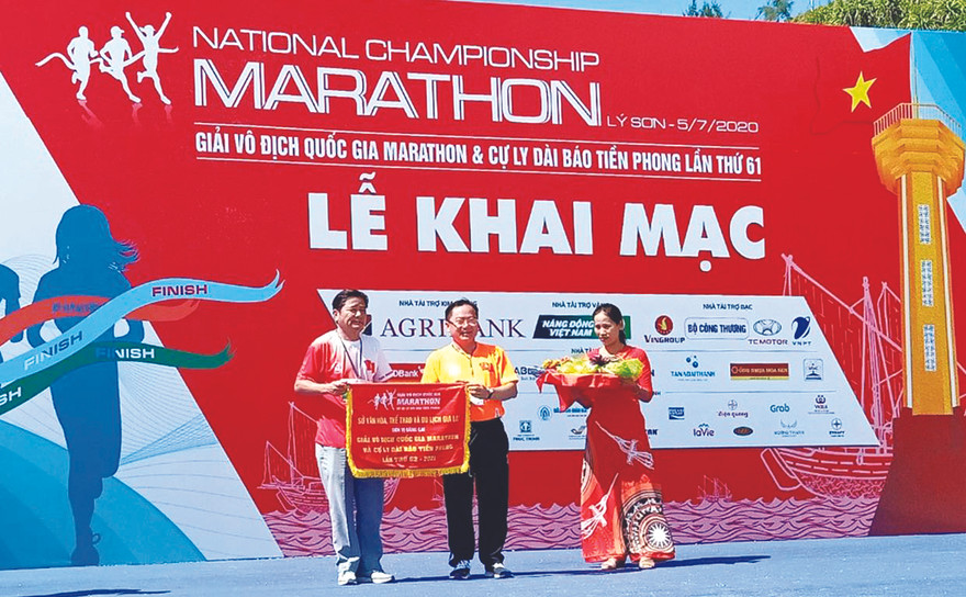 Ông Trần Ngọc Nhung - Giám đốc Sở VHTTDL Gia Lai, nhận cờ đăng cai tổ chức giải năm 2021 từ trưởng BTC Tiền Phong Marathon 2020 Lê Xuân Sơn. Ảnh: Như Ý