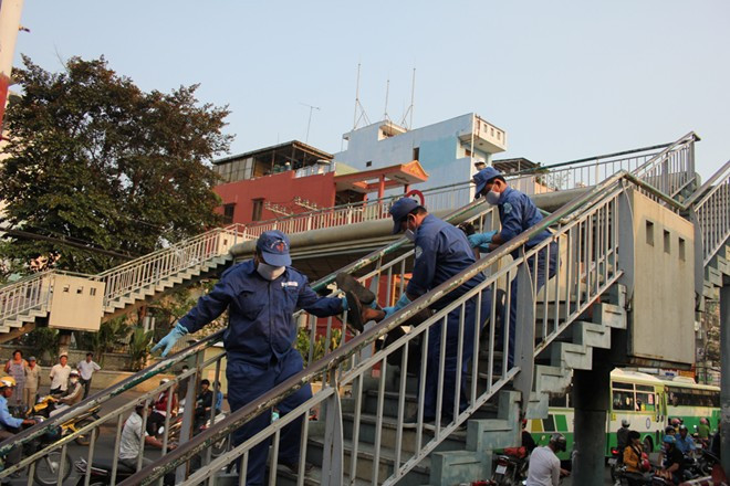 Nhân viên công ty vệ sinh môi trường đưa thi thể nam thanh niên xuống xe chở về nhà xác bệnh viện 