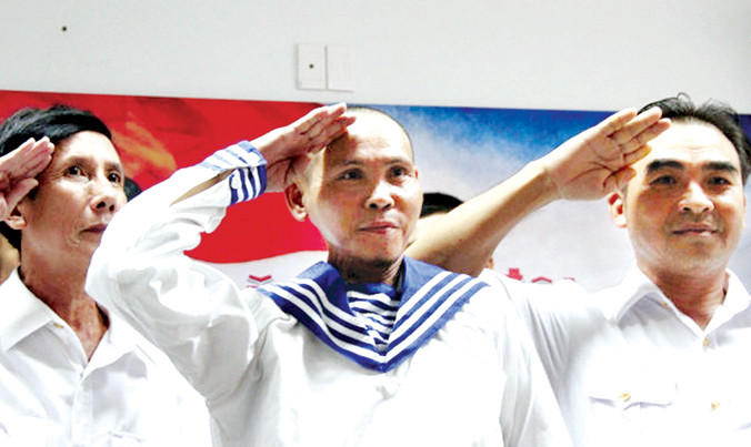 Anh Dũng (giữa) và những cựu binh Gạc Ma đưa tay chào theo điều lệnh