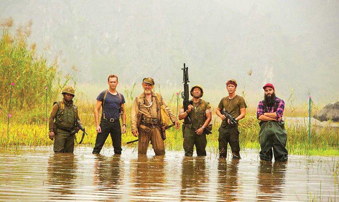 Đạo diễn (bìa phải) lội nước cùng dàn diễn viên.