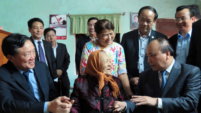 Thủ tướng Nguyễn Xuân Phúc cùng đoàn công tác đến dâng hương tại khu lưu niệm mẹ Thứ và thăm các gia đình chính sách tại Quảng Nam (trong ảnh: Thủ tướng Nguyễn Xuân Phúc thăm hỏi và động viên mẹ Lê Thị Trị). Ảnh: Nguyễn Sơn (TTXVN)