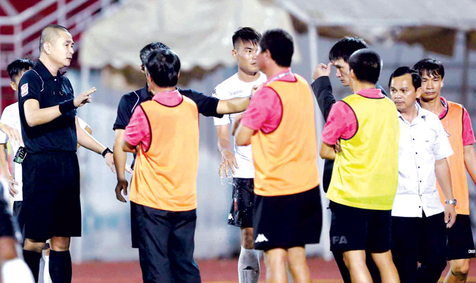 Ông Võ Thành Nhiệm (áo trắng, bìa phải) quyết định từ chức chủ tịch CLB Long An sau sự cố đầy tai tiếng trên sân Thống Nhất cuối tuần qua. Ảnh: VSI