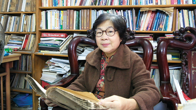 Đỗ Bạch Mai bên di cảo của chồng. Ảnh: Hồng Vĩnh