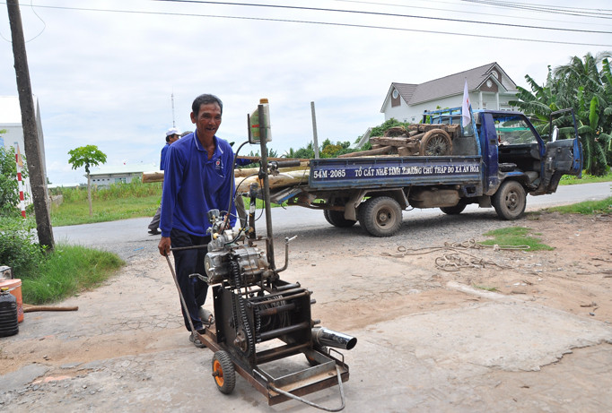 Ông Nguyễn Thanh Tâm đem đồ nghề vào nhà. Ảnh: Hòa Hội.