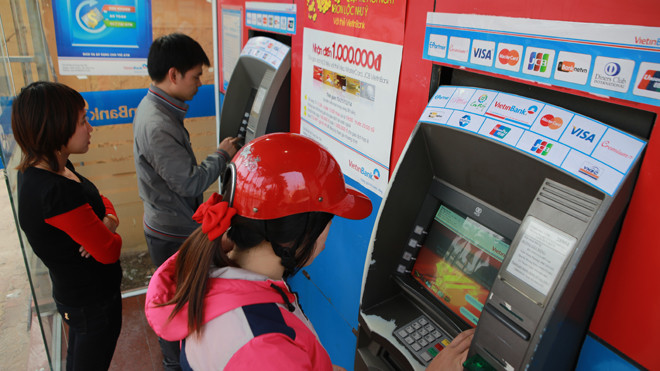 Người dân Hà Nội rút tiền từ cây ATM dịp cuối năm. Ảnh: Như Ý