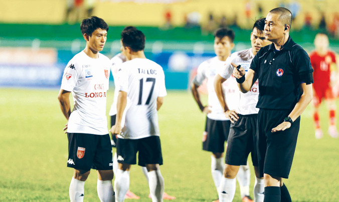 Trọng tài nhắc nhở các cầu thủ đội Long An trong vụ việc “bỏ cuộc” đầy tai tiếng trên sân Thống Nhất.