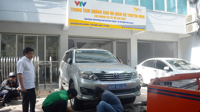 Chiếc xe biển xanh đậu trên vỉa hè bị học lượng chức năng quận 1 cẩu về trụ sở công an. Ảnh: Ngô Bình