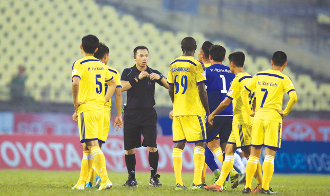 Các cầu thủ SLNA phản ứng với trọng tài Trung Kiên B ở tình huống bị thủng lưới sau khi thủ môn Nguyên Mạnh bị phạm lỗi trong khu 5.50m. Ảnh: VSI