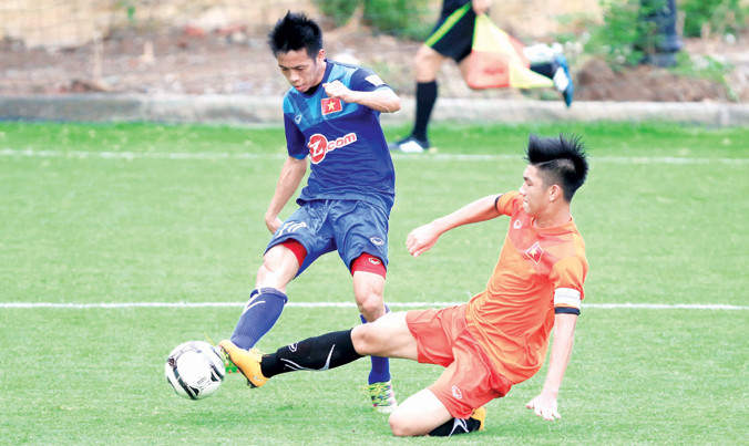 Trung vệ trẻ Trọng Đại (phải) đối đầu với đàn anh Văn Quyết trong một buổi đấu tập giữa U19 và ĐTVN. Ảnh: VSI