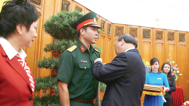Thủ tướng Nguyễn Xuân Phúc gắn tặng huân chương Lao động hạng Nhất cho Hoàng Xuân Vinh hồi tháng 8/2016. Ảnh: Như Ý