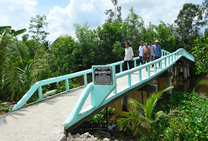Bà con hân hoan đi trên những cây cầu mới do nhóm xây cầu thiện nguyện xã Tân Long (thị xã Ngã Năm) xây dựng. Ảnh: Cao Xuân Lương.