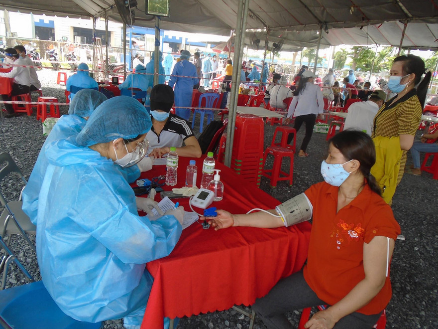 Tiểu thương chợ Bình Ðiền (TPHCM) được tiêm vắc-xin COVID-19. Ảnh: Uyên Phương
