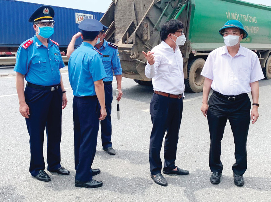 Chủ tịch Thành phố Hà Nội Chu Ngọc Anh (áo trắng - bìa phải), Giám đốc Sở GTVT Hà Nội Vũ Văn Viện (áo trắng - đứng giữa) và Chánh Thanh tra Sở GTVT Trần Nhật Quang (sắc phục Thanh tra GTVT - bìa trái) đi kiểm tra, thực tế tại chốt kiểm soát Phù Ðổng (QL1) ngày 26/7/2021