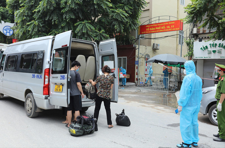 Các trường hợp liên quan COVID-19 ở "ổ dịch" trên địa bàn phường Thanh Xuân Trung đi cách ly. Ảnh: Như Ý