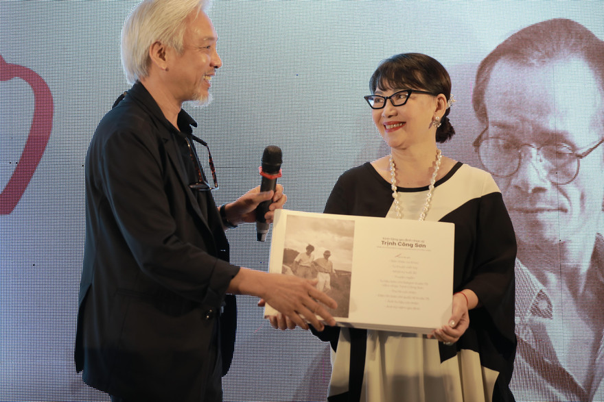 Ca sĩ Trịnh Vĩnh Trinh thay mặt gia đình nhạc sĩ nhận món quà quý từ nhiếp ảnh gia Dương Minh Long 