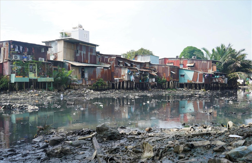 Nhà lụp xụp trên rạch Xuyên Tâm. Con rạch không còn chức năng thoát nước và ô nhiễm nặng vì chứa rác thải