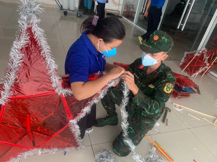 Cán bộ chiến sĩ hỗ trợ tại chung cư 1050 làm lồng đèn tặng cho thiếu nhi. Ảnh: U.P