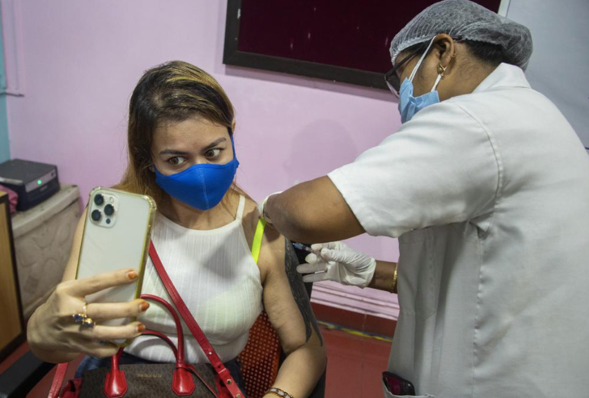 Một phụ nữ Ấn Ðộ tự chụp ảnh khi đang được tiêm vắc-xin ở bang Assam ngày 17/5. Ảnh: AP