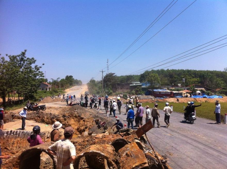 Người dân chặn xe cẩu không cho vận chuyển hai khúc gỗ đi.