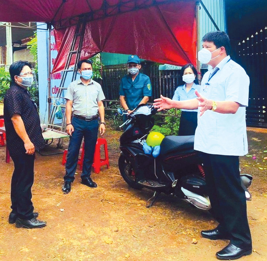 Chủ tịch huyện Nguyễn Văn Hà (bìa phải) đang trao đổi công việc tại chốt kiểm dịch