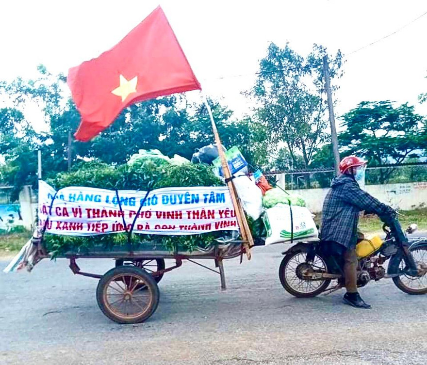 Trên chiếc xe kéo chất đầy nhu yếu phẩm, ông Phạm Công Duyên chở vào tiếp sức cho người dân thành phố Vinh