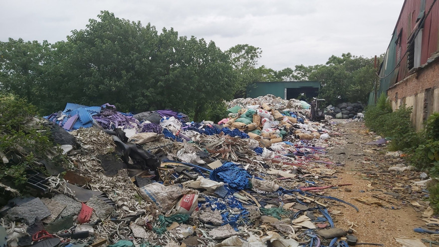 Vải vụn, cao su hay nhựa thải được chủ các nhà xưởng tập kết về làm chất đốt, nấu nước để nhuộm, hấp vải phía ngoài đê sông Đáy