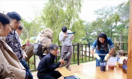 Du khách trải nghiệm nhuộm sợi cùng chị Bon Niêng K’Gút (bìa phải)