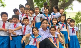Thầy giáo Nguyễn Tấn Thuyên và các em học sinh Ảnh: Văn Chương
