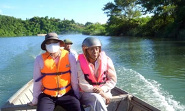 Gần 70 tuổi, ông Hoàng Xuân Ninh (bên phải) vẫn miệt mài ngược xuôi dòng Đại Giang mang vốn chính sách về với đồng bào Bru Vân Kiều