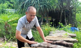 Nghệ nhân Nguyễn Minh Nghiệp giới thiệu bộ đàn đá nguyên bản gồm 17 thanh chưa qua chế tác Ảnh: Huyền Oanh 