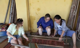 Du khách tập dệt chiếu dưới sự hướng dẫn của chị CôngẢnh: Giang Thanh