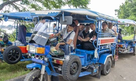 Xe 3 bánh đưa khách tới thăm chợ đêm bán đồ ăn vặt Lào Chaleun Ảnh: Lê Văn Chương 