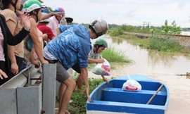 Người dân hỗ trợ nhu yếu phẩm cho bà con các khu vực bị ngập sâu, cô lập Ảnh: Giang Thanh