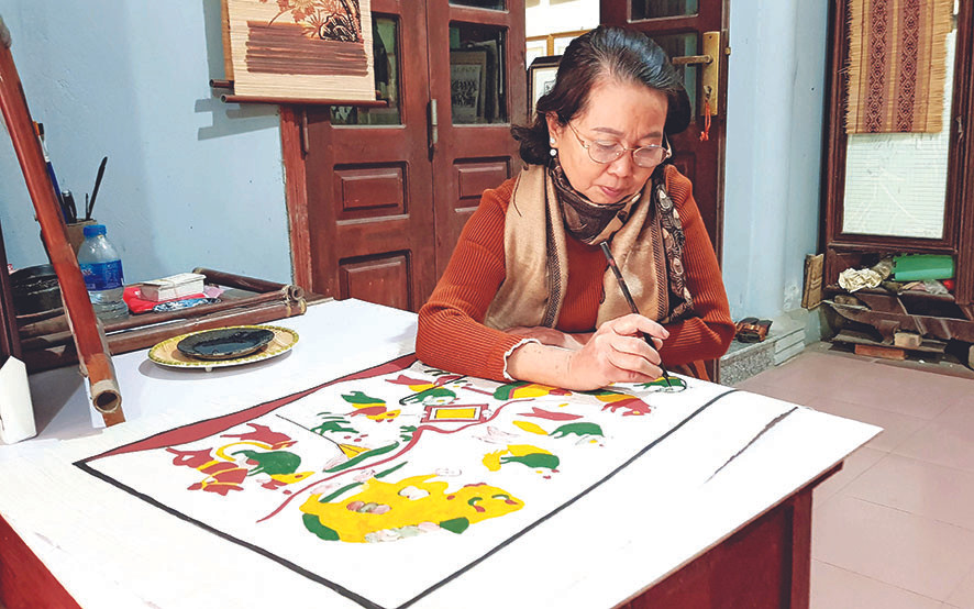 Nghệ nhân Nguyễn Thị Oanh vẽ bức tranh “Đám cưới chuột” Ảnh: KIẾN NGHĨA Từ 'Đám cưới chuột', nhớ tranh Đông Hồ ngày Tết ảnh 2