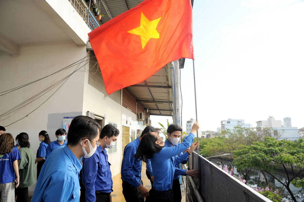 Các bạn đoàn viên thay cờ Tổ quốc mới cho chung cưng Lò Gốm, Q.8. Thành Đoàn TP. HCM ra quân các hoạt động hưởng ứng Tháng Thanh niên ảnh 1
