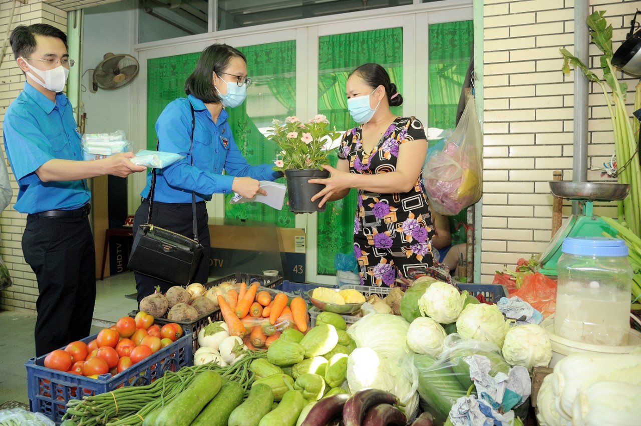Các bạn đoàn viên, thanh niên tặng hoa và khẩu trang cho tiểu thương chợ Q. 6. Thành Đoàn TP. HCM ra quân các hoạt động hưởng ứng Tháng Thanh niên ảnh 2