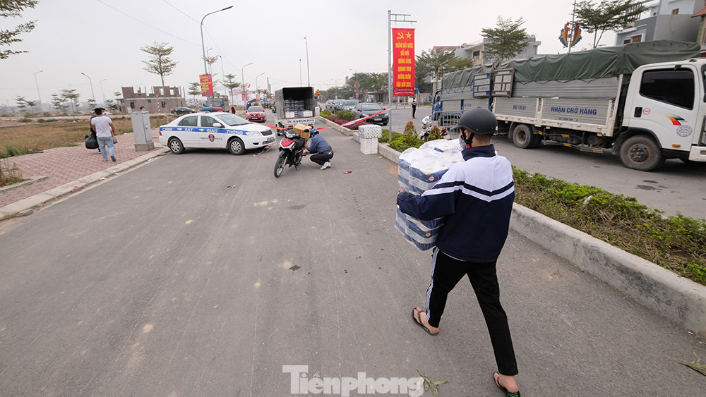 Một thanh niên vận chuyển hàng từ phía ngoài vào xe tải đỗ bên trong khu vực phong tỏa. Hàng loạt địa phương ở Hải Dương bị phong tỏa, cách ly ảnh 7