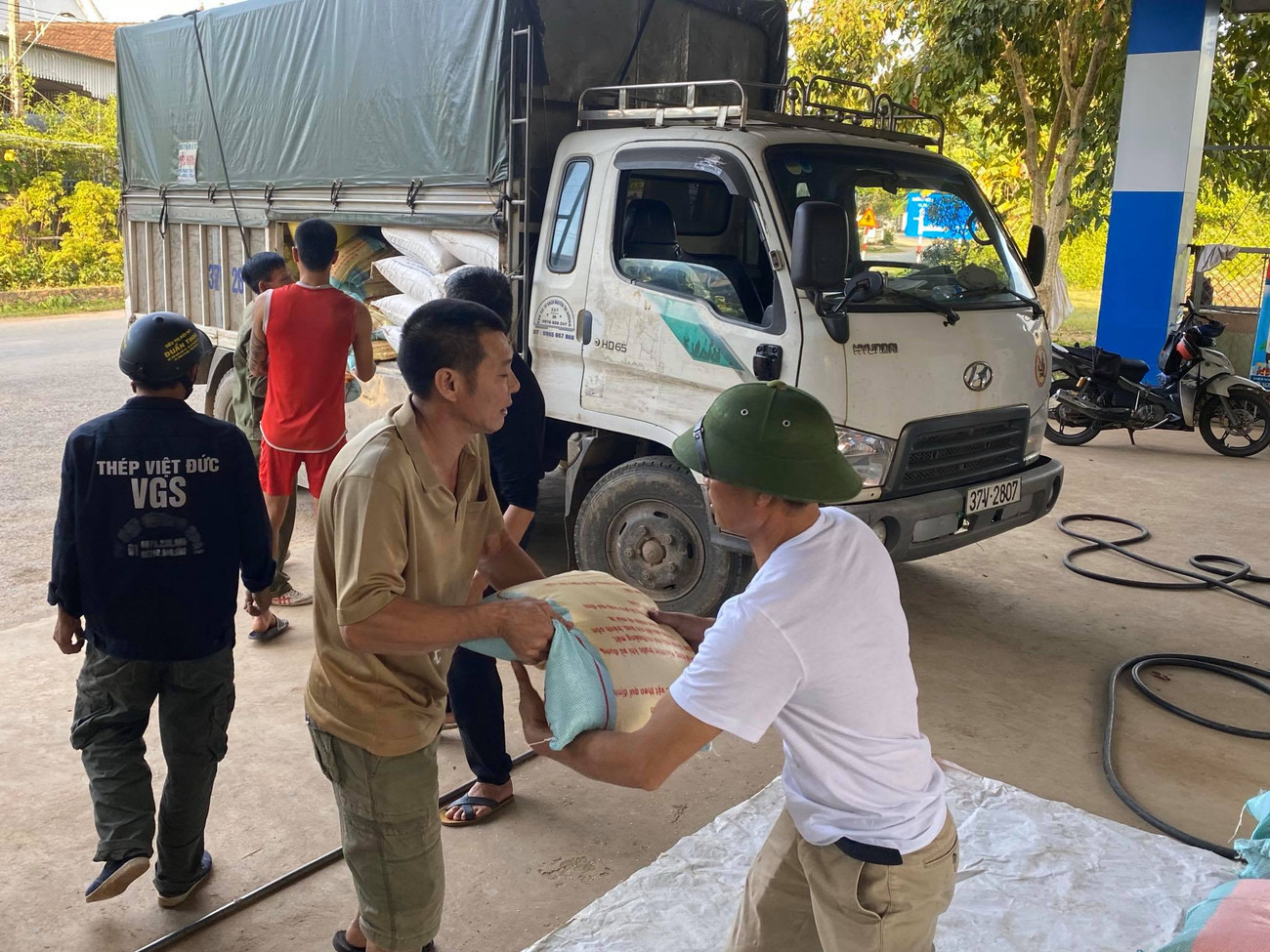 Con cháu cụ Dỏng và người dân địa phương bốc vác gạo lên xe để vào rốn lũ. Cụ ông 98 tuổi kêu gọi con cháu ủng hộ 3 tấn gạo cho đồng bào miền Trung ảnh 2