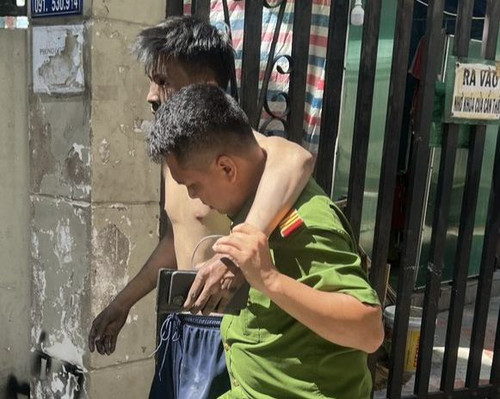 Cảnh sát dìu một nạn nhân ra khỏi vụ cháy. Ảnh: C.A.