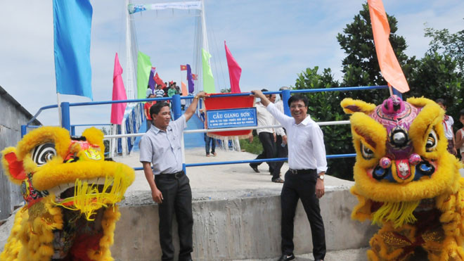Đại diện Tập đoàn Merap, CLB Bóng đá HAGL và lãnh đạo địa phương cắt băng khánh thành cầu Giang Sơn. Ảnh Minh Đức