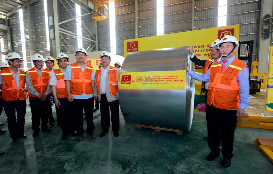 Lãnh đạo Tập đoàn Hoa Sen và lãnh đạo tỉnh Nghệ An bên cuộn tôn thương phẩm đầu tiên của Nhà máy Hoa Sen Nghệ An Đông Hồi. 