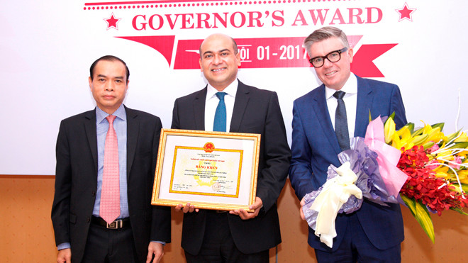 Đại diện NHNN (trái) trao tặng Bằng khen Thống đốc NHNN cho Tổng Giám đốc Công ty Tài chính Prudential (giữa). Ảnh: Minh Vũ