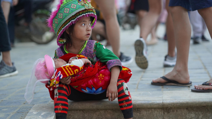  Con em bà con dân tộc địu em đang còn “đỏ hỏn” trên lưng đi xin tiền bán hàng rong khiến nhiều du khách xót xa, thương cảm. 