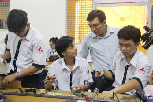 Thầy giáo Huỳnh Kiều Viết Lãm và học trò trong phòng thực hành . Ảnh: Giáo Dục Thời Đại.
