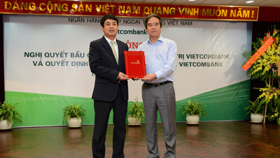 Ông Nguyễn Văn Bình - Ủy viên BCH Trung ương Đảng - Thống đốc Ngân hàng Nhà nước Việt Nam (bên phải) trao Nghị quyết về việc bầu Chủ tịch Hội đồng quản trị Vietcombank cho ông Nghiêm Xuân Thành - tân Chủ tịch HĐQT Vietcombank;