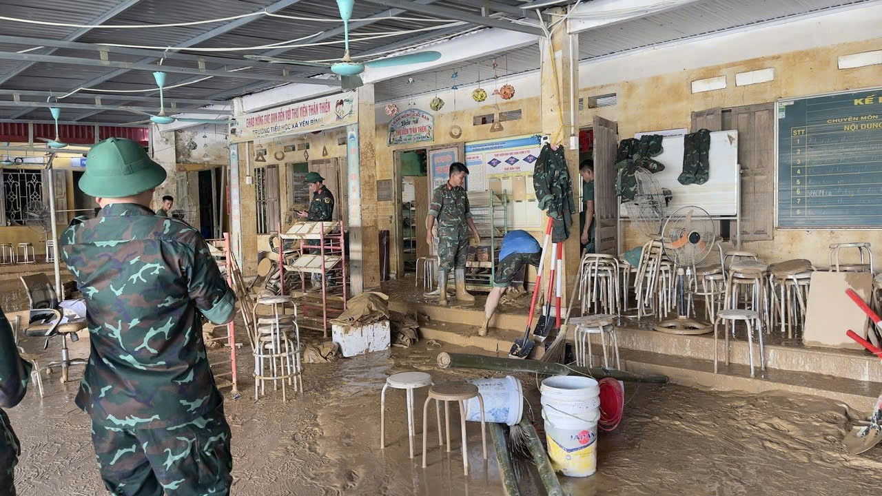 Officieren en soldaten van het Defensiecommando van Gebied 3 Nhan Ly ruimen spullen op van studenten in het overstromingscentrum van de gemeente Yen Binh. Foto: Duy Chien. b3.jpg